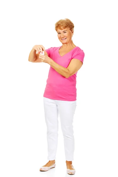 Sorridente donna anziana in possesso di vaso di pillole — Foto Stock