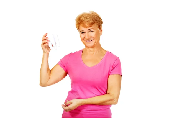 Sorrindo mulher idosa segurando um modelo de dente — Fotografia de Stock