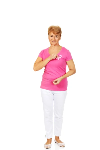 Sorridente donna anziana con il nastro di consapevolezza del cancro al seno — Foto Stock