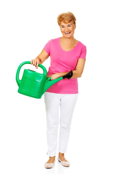 Yeşil sulama kutusuyla gülümseyen yaşlı kadın. — Stok fotoğraf