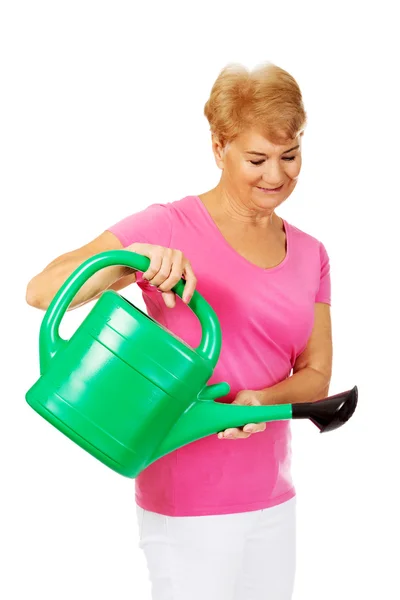 Smiling senior woman with green watering can — Stock Photo, Image