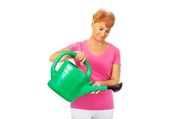 Smiling senior woman with green watering can — Stock Photo, Image