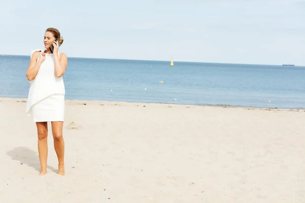 Giovane elegante bella donna che parla al telefono sulla spiaggia — Foto Stock