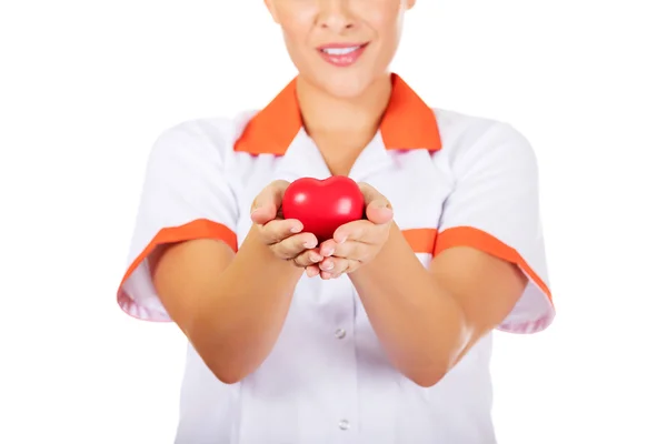 Young female doctor or nurse holding toy heart — Stock Photo, Image