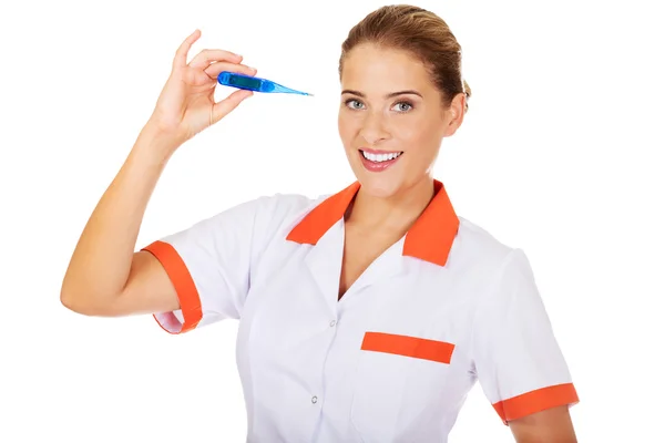 Genç kadın doktor veya hemşire holding termometre — Stok fotoğraf