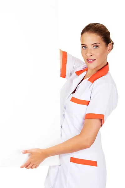 Médica feliz segurando banner vazio — Fotografia de Stock