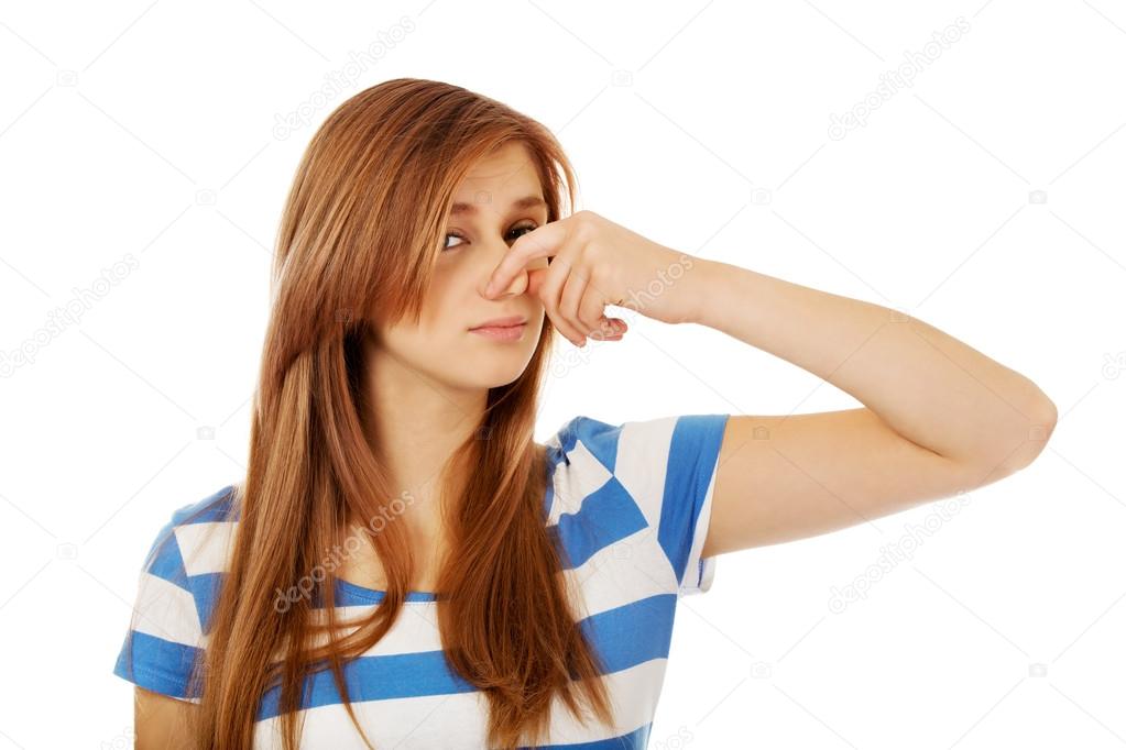 Teenage woman holding her nose because of a bad smell