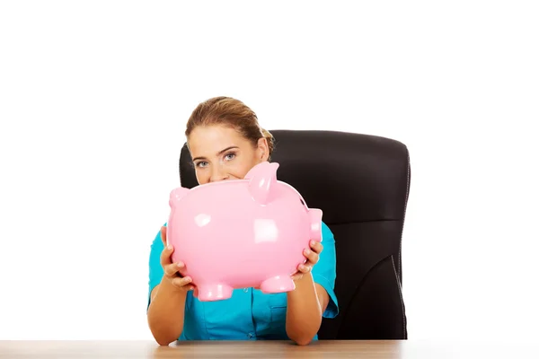 Vrouwelijke arts bedrijf piggy bank — Stockfoto