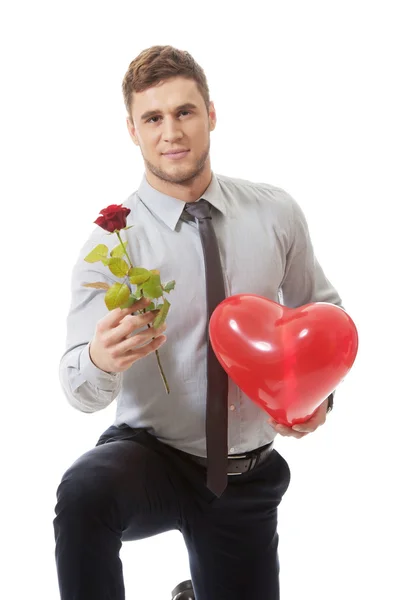 Man kneeling with red rose — Stock Photo, Image