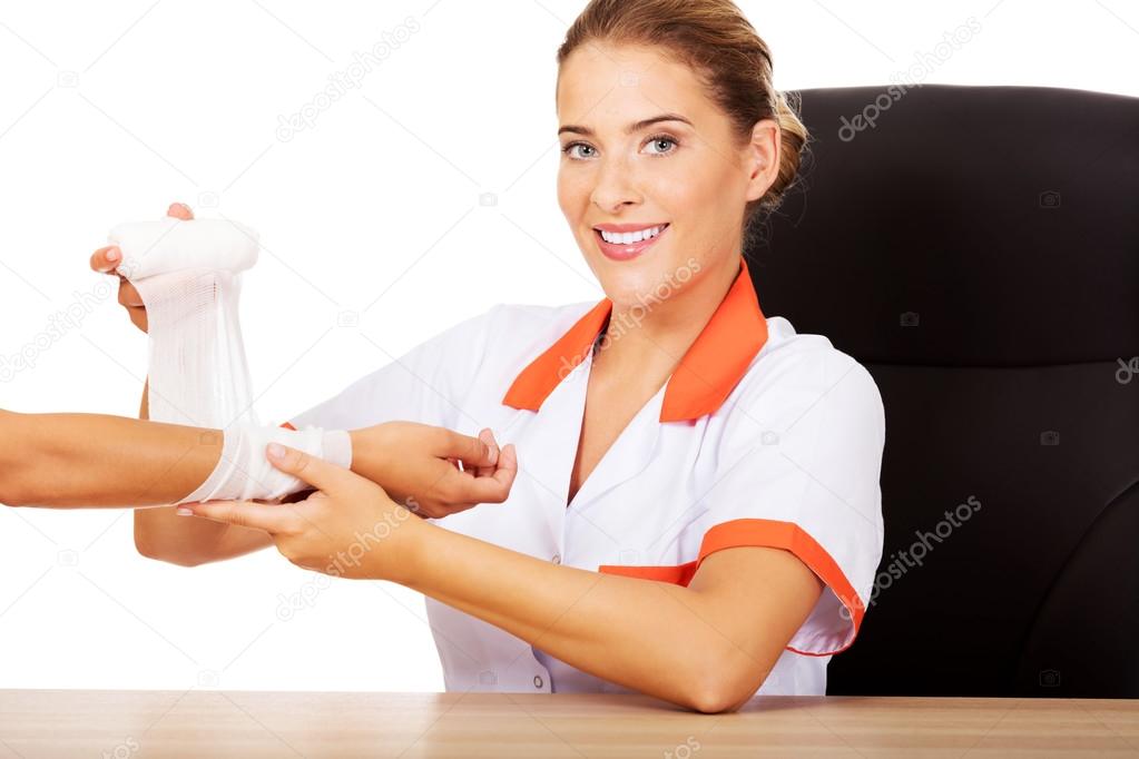 doctor bandaging female hand