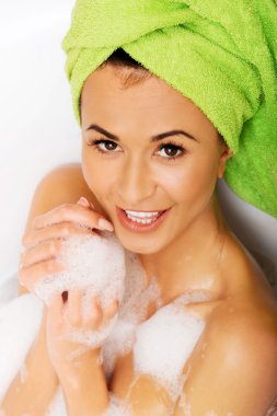 Kadın kameraya bakarak banyosunda rahatlatıcı