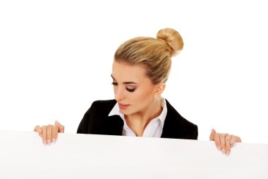Boş afiş tutarak gülümseyen iş kadını
