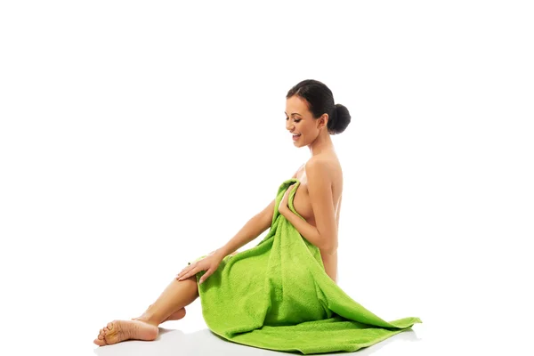 Kobieta roześmiany siedzący zawinięte w ręcznik — Zdjęcie stockowe