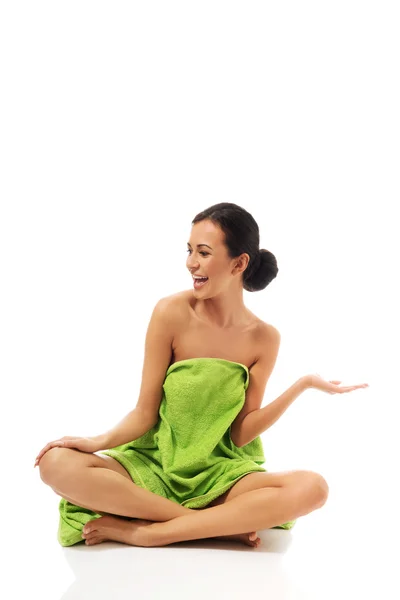 Woman sitting cross-legged wrapped in towel — Stock Photo, Image