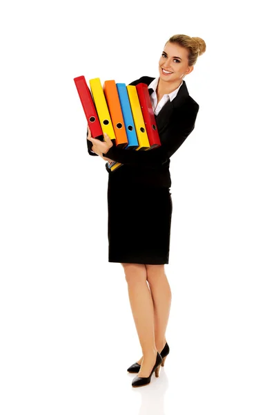 Jonge zakenvrouw draagt zware bindmiddelen — Stockfoto