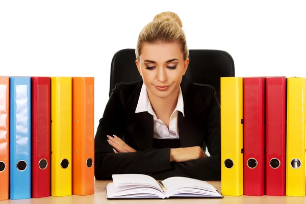 Exhausted businesswoman with binders behind the desk — Stock Photo, Image