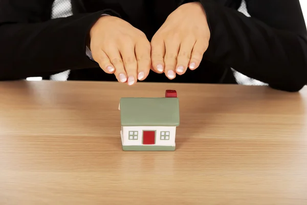 Бізнес-леді з маленьким будинком за столом — стокове фото