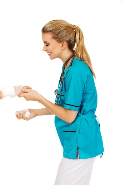 Jeune femme médecin bandage main femme — Photo