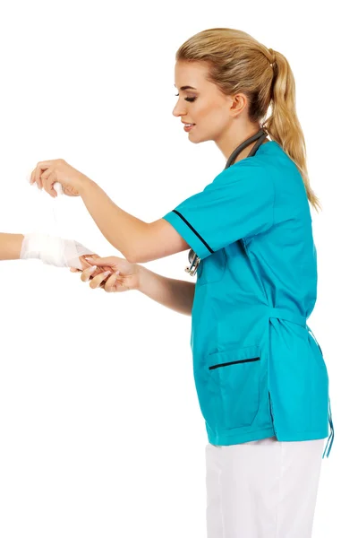 Νεαρή γυναίκα γιατρό επίδεση γυναίκα χέρι — Φωτογραφία Αρχείου