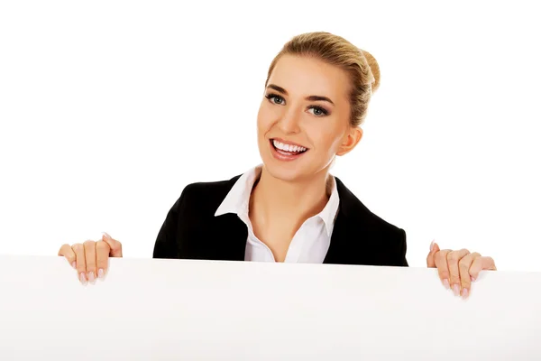 Mujer de negocios sonriente sosteniendo banner vacío —  Fotos de Stock