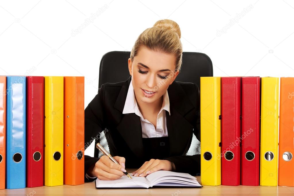 Smile businesswoman with binders by a desk