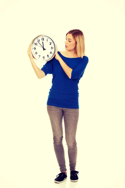 Mujer conmocionada sosteniendo un reloj . Imagen De Stock