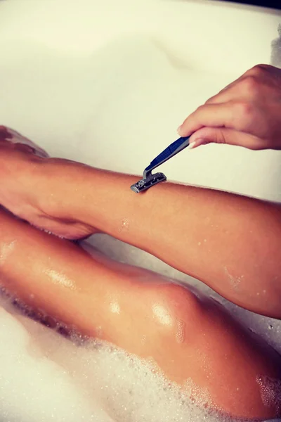Женщина бреет ноги — стоковое фото