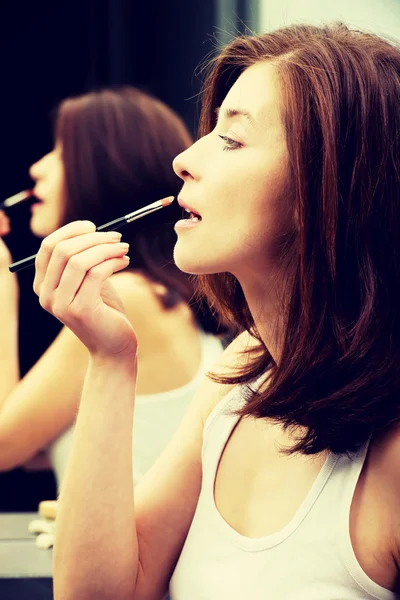 Frau trägt Lippenstift auf. — Stockfoto