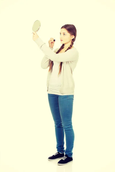 Teen woman applying lipstick looking at mirror. — Stock Photo, Image