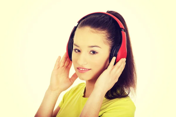 Ung kvinna med hörlurar lyssnar på musik. — Stockfoto