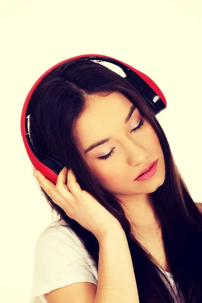 Skalní žena se sluchátky poslechu hudby. — Stock fotografie