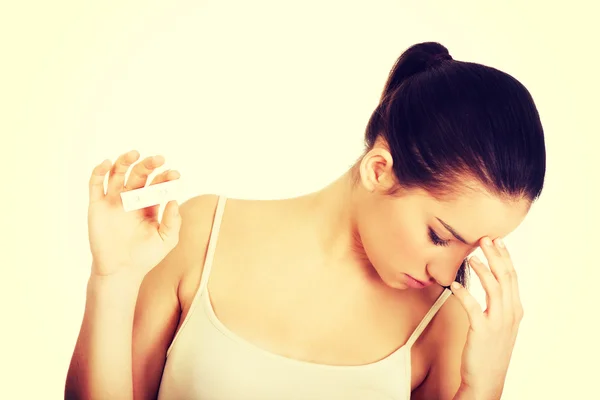 Depressed woman with pregnancy test. — Stock Photo, Image