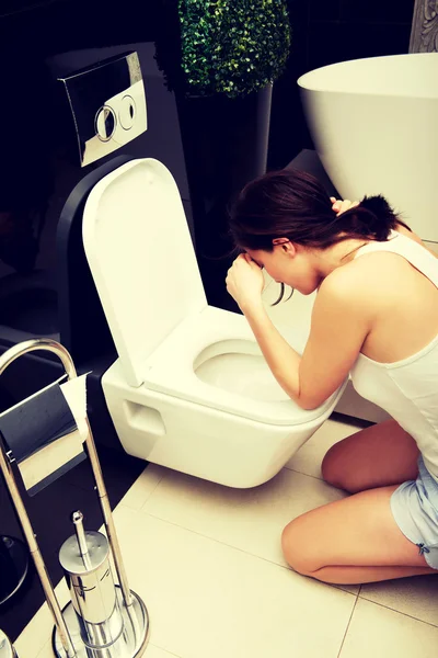 Woman vomiting in toilet. — Stock Photo, Image