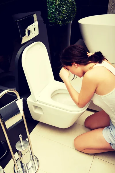 Mulher vomitando no banheiro . — Fotografia de Stock