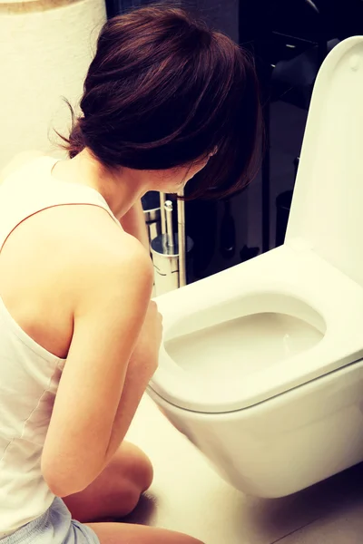 Mulher vomitando no banheiro . — Fotografia de Stock