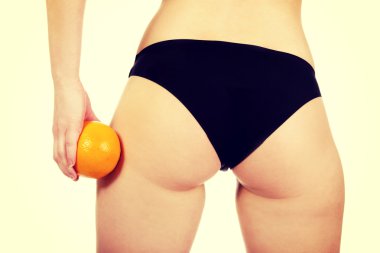 Kadın kalça ve turuncu elinde.