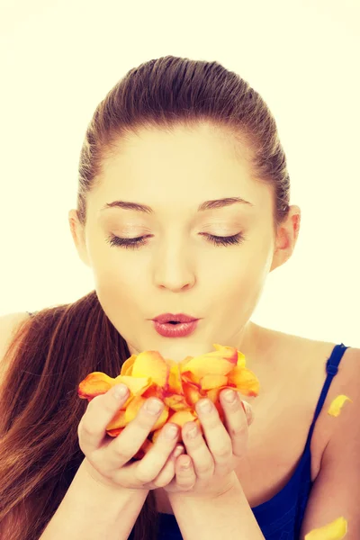 Young woman blowing rose petals. — Stock Photo, Image