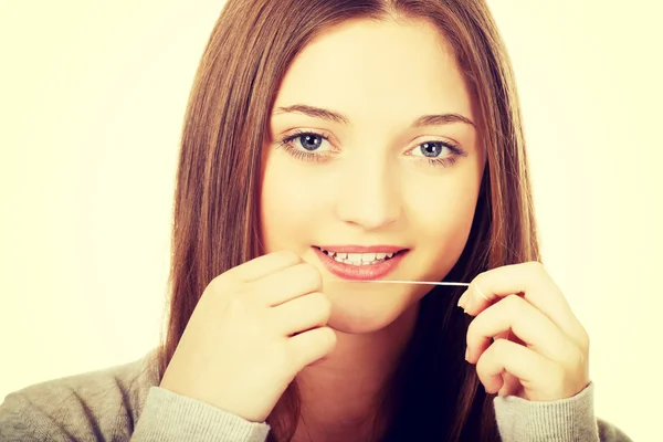 Nastolatka kobieta z nici dentystyczne. — Zdjęcie stockowe
