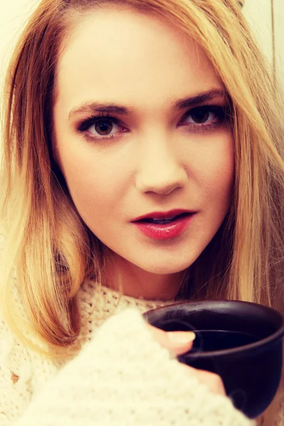 Mooie vrouw drinken koffie in de keuken. — Stockfoto