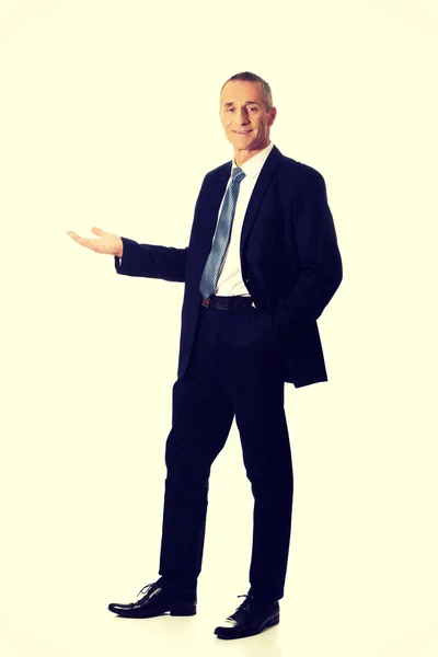 Businessman holding something on his palm — Stock Photo, Image