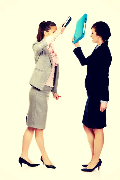 Angry businesswomen fighting with their binders. — Stock Photo, Image