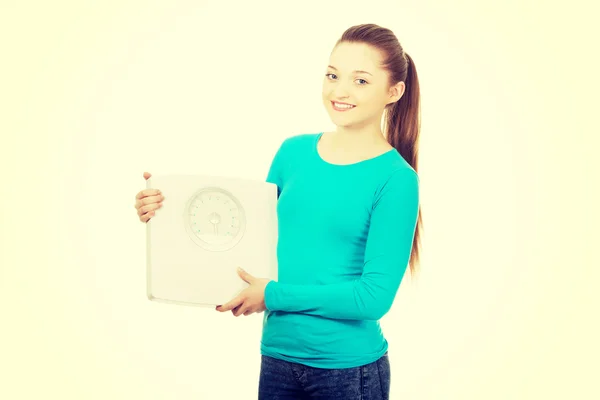 Beautiful teenager holding a scale. — Stock Photo, Image