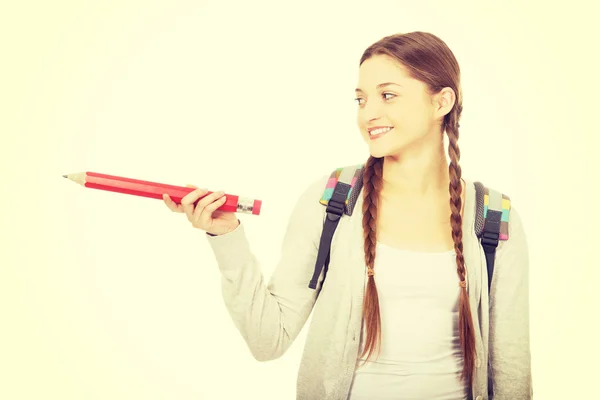 Schoolgirl pointing aside with pencil. — Stock Photo, Image