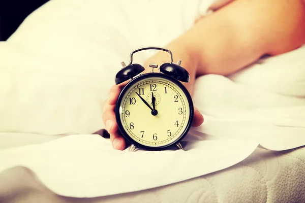 Hombre con despertador en el dormitorio. — Foto de Stock