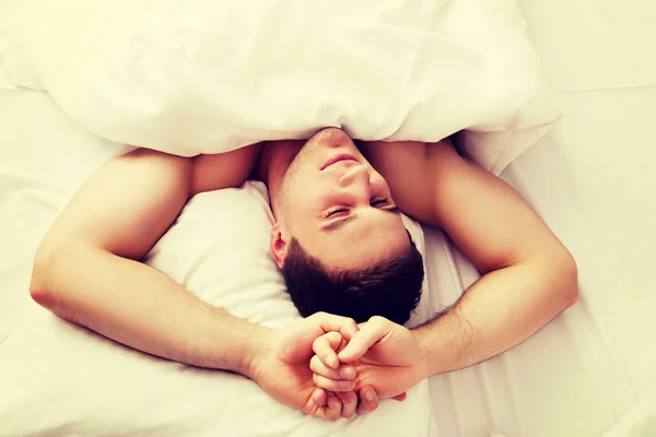 Bonito jovem deitado na cama. — Fotografia de Stock