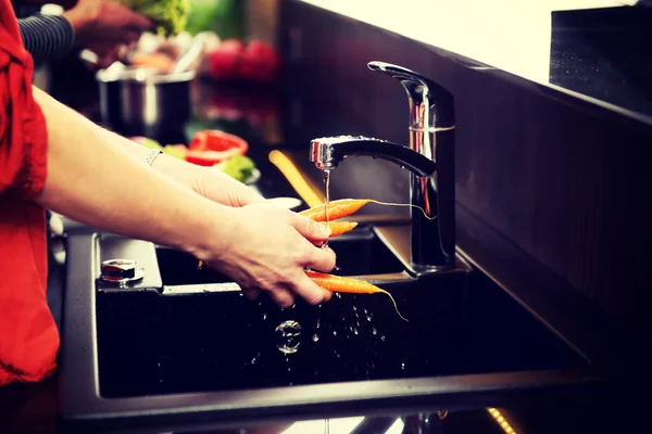 Woman washing carrots. — Stock Photo, Image