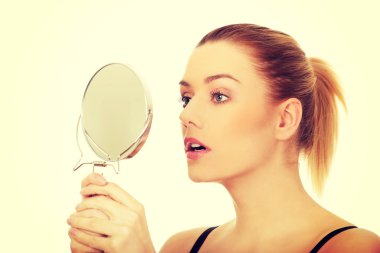 Bir ayna tutan genç kadın.