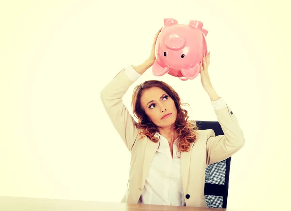 Geschäftsfrau schüttelt Sparschwein. — Stockfoto