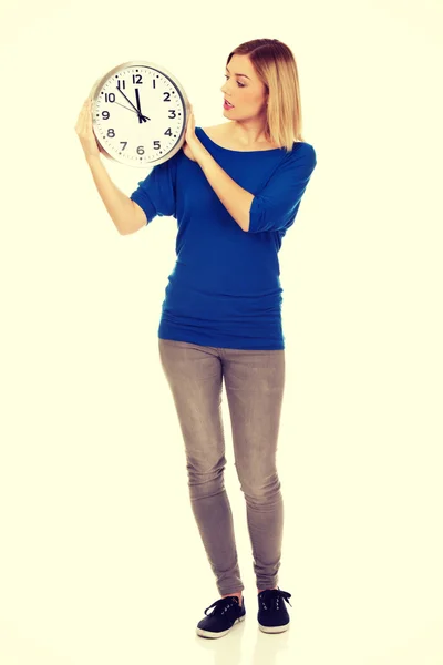 Mujer conmocionada sosteniendo un reloj . —  Fotos de Stock