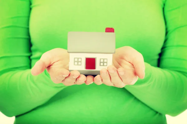 Mujer sosteniendo pequeña casa . — Foto de Stock